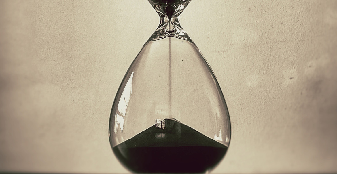 Hourglass with sand running through it.