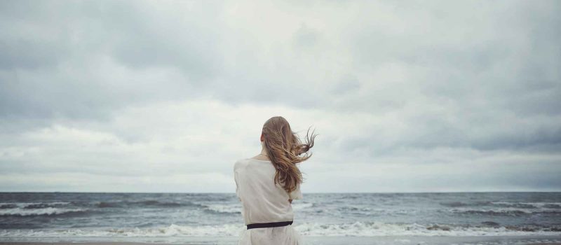 Woman staring at the ocean.