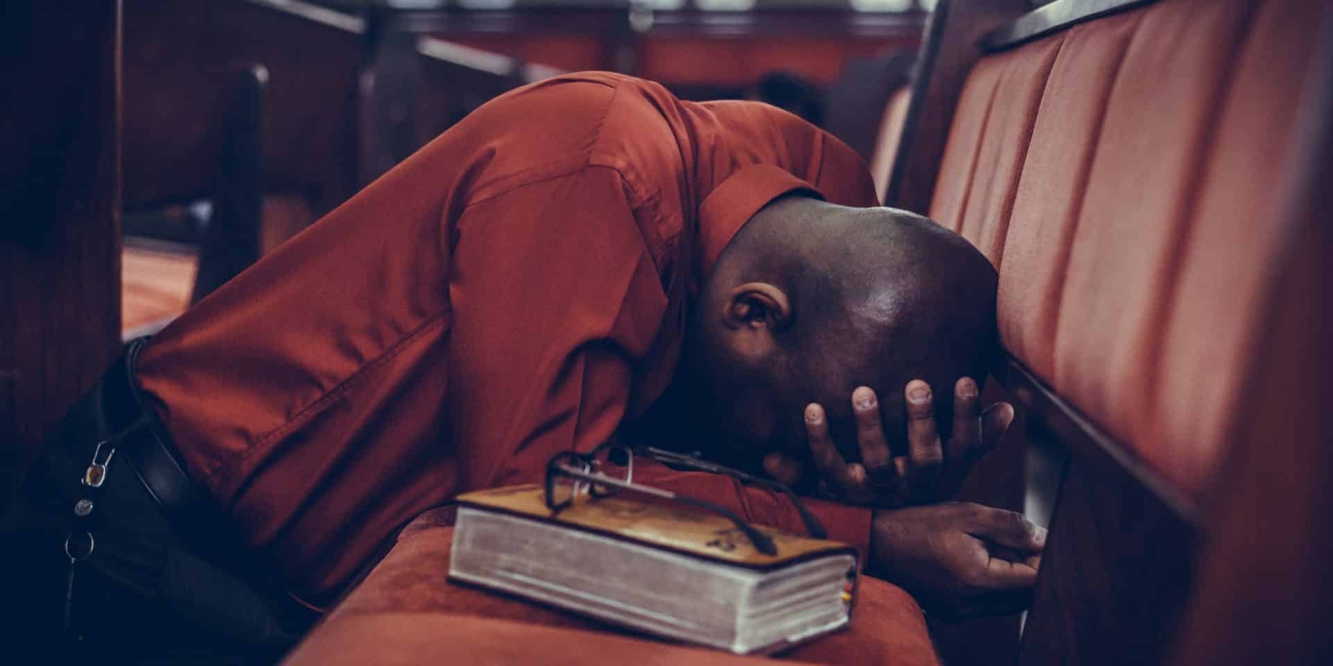 Man praying with his head in his hand...