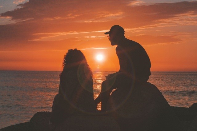 Couple talking with sunset behind them.