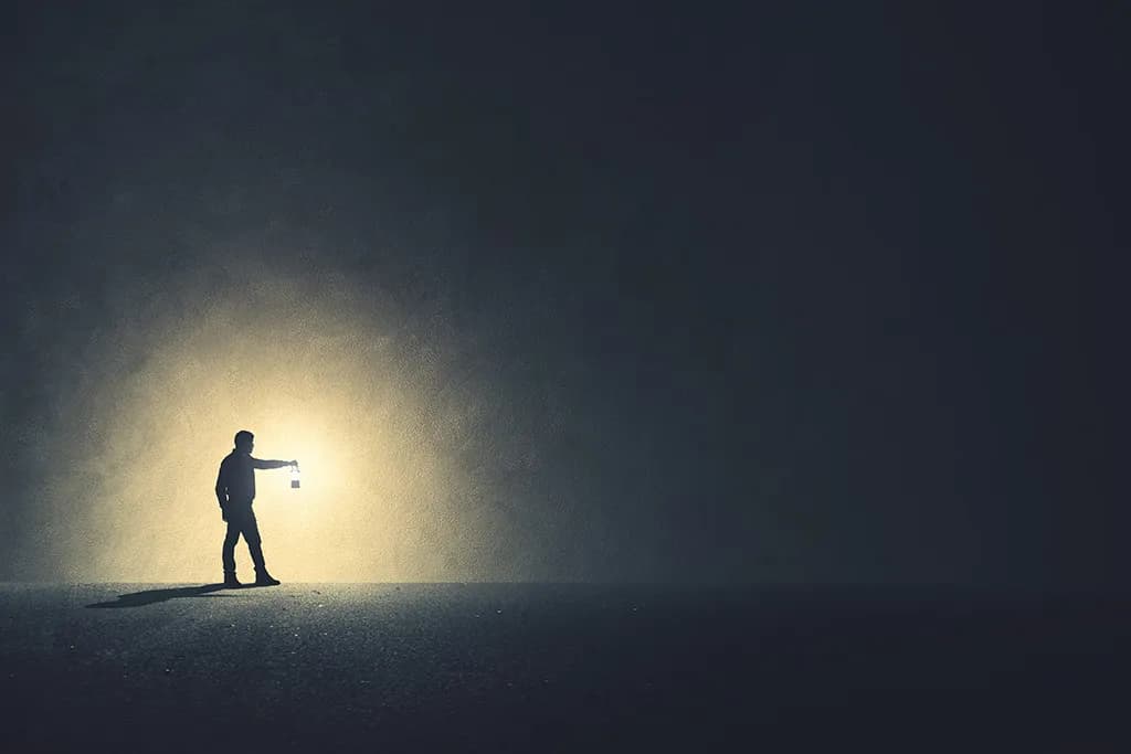 Man looking up into the sky toward a light.