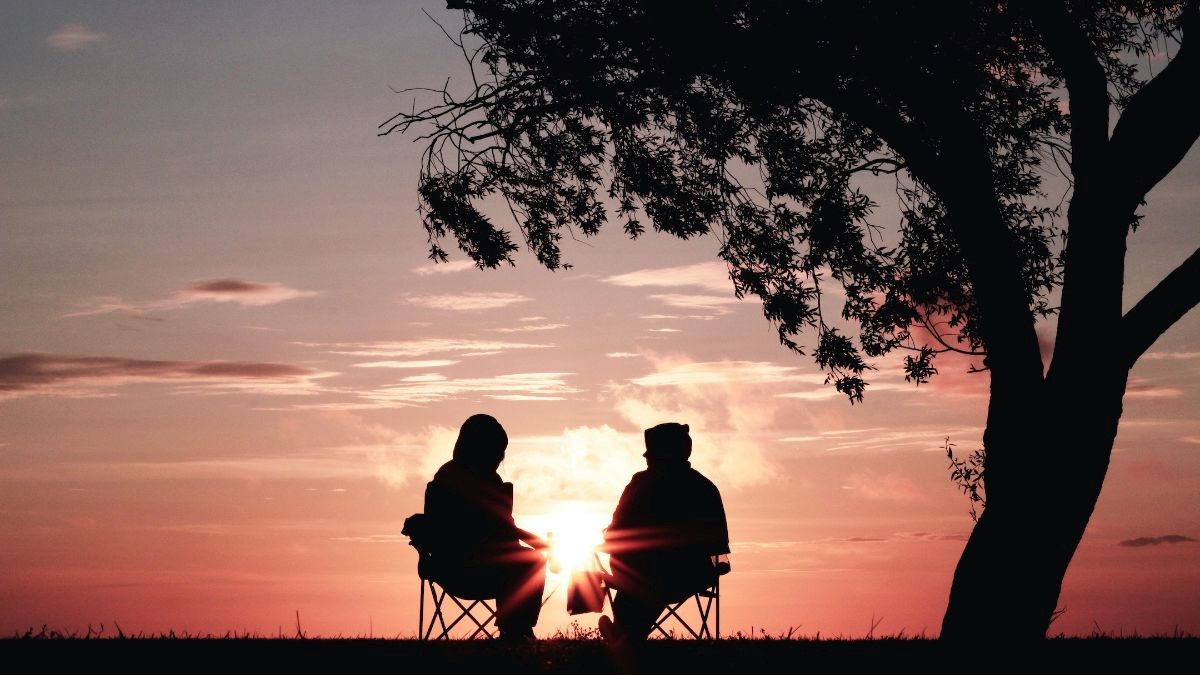 Two people sitting watching sunset